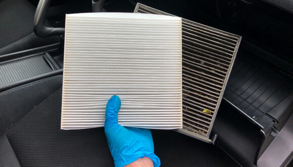 The new and clean cabin air filter is compared to the old and dirty cabin air filter
