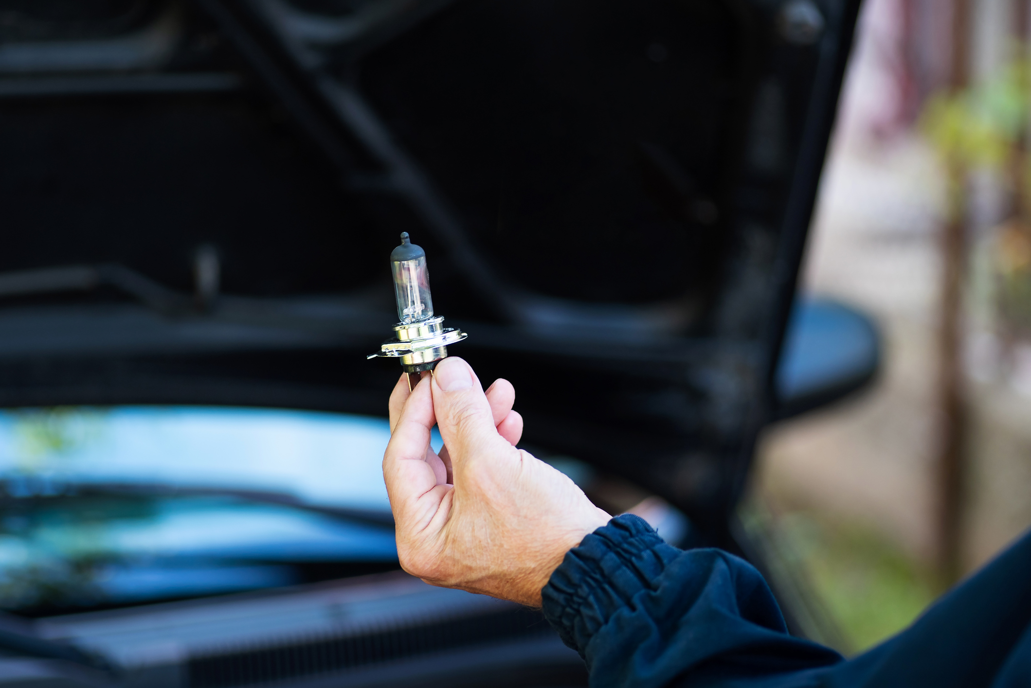 person holding car headlight bulb